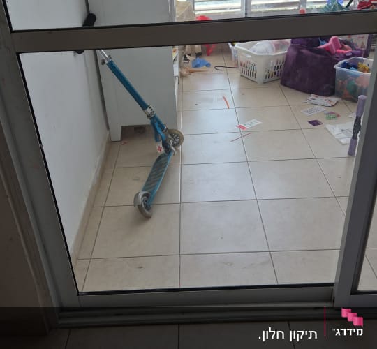 מרפסת עם חלונות תריסים וצעצועים על הרצפה